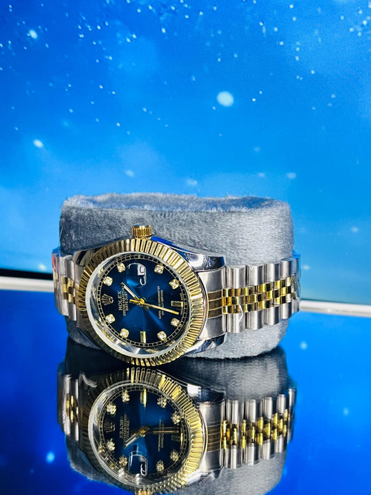 Luxury watch with blue face and gold accents on a reflective surface with a blue gradient background